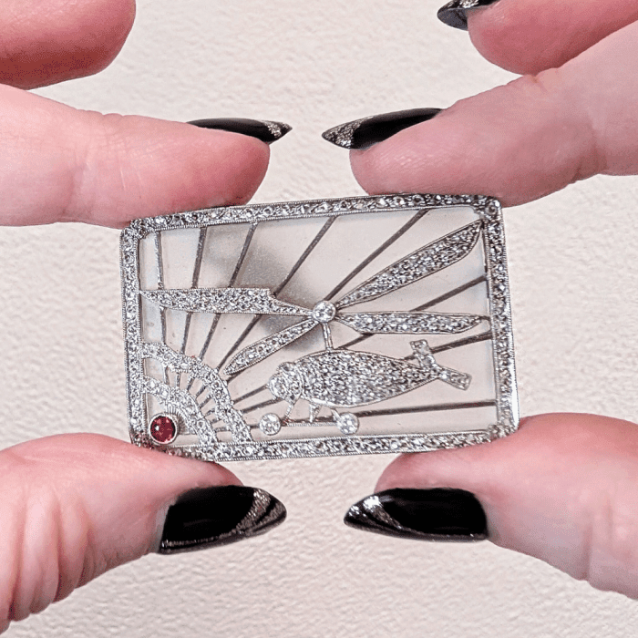 This Art Deco rock crystal, diamond, and ruby brooch shows an early helicopter. From The Eden Collective, seen at NYCJAOS.