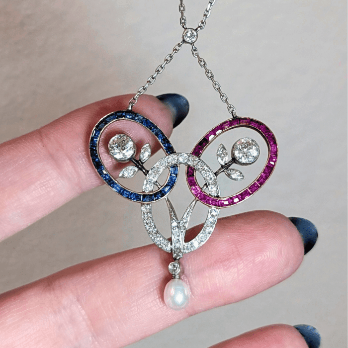 This beautiful Edwardian era necklace has diamonds, sapphires, rubies, and a pearl. From L & Z Antique, seen at NYCJAOS Autumn 2025