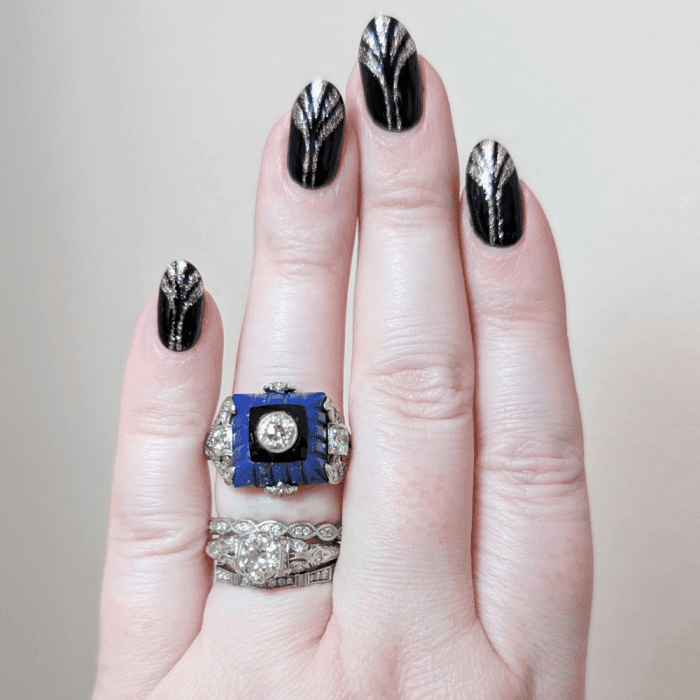 Art Deco diamond ring with carved lapis, onyx, and diamonds, on hand. From The Vintage Jeweller.