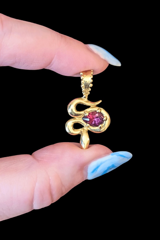 Delphine Leymarie garnet snake charm in 14K yellow gold from Beaumont Jewelry Collective.