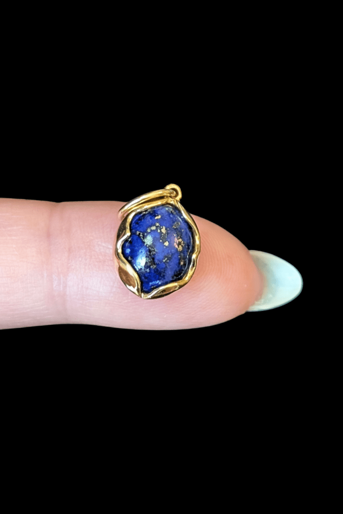 Delphine Leymarie lapis lazuli lotus charm in 14K yellow gold from Beaumont Jewelry Collective.