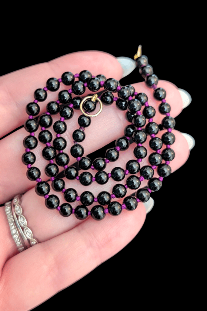 Delphine Leymarie open ended Onyx bead strand on purple silk from Beaumont Jewelry Collective.