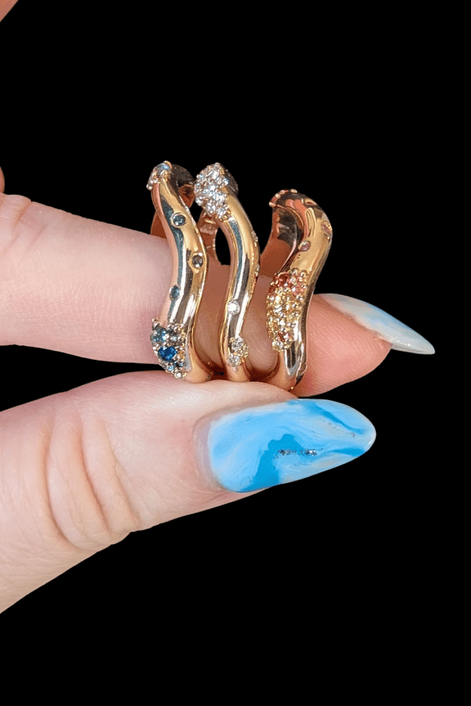 Dylann Wolfe Shimmering Tides stacking rings in Fairmined gold with sapphires and recycled diamonds, from Beaumont Jewelry Collective.
