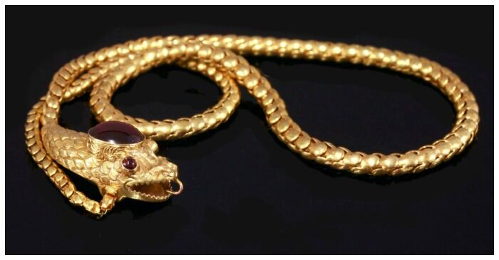 An antique Victorian snake necklace in gold with topaz, garnet, chrysoberyl.