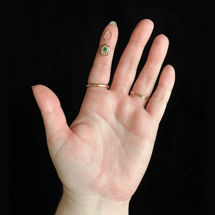 The Kimberly Doyle Gemagotchi charm in gold with an emerald. Fine jewelry inspired by the 90's Tamagotchi craze!