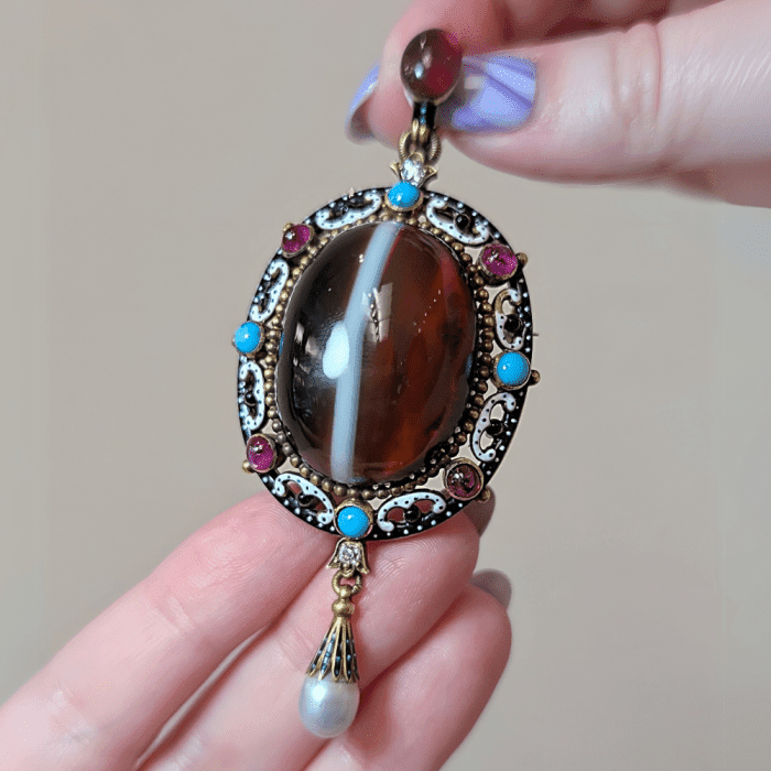 An antique banded agate pendant with gemstones, enamel, and pearls. From Legacy London.