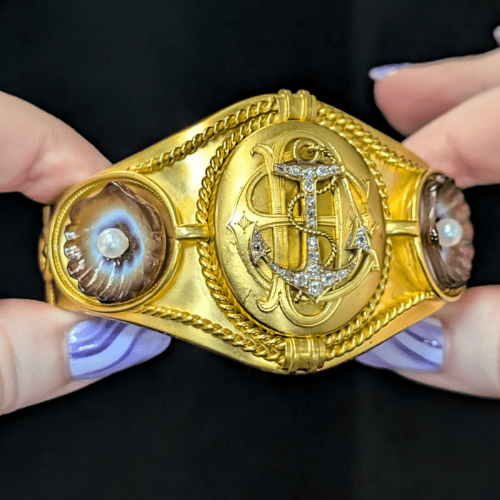 Antique gold cuff bracelet with diamond anchor, monogram, and carved agate shells. Seen at Courtville Antiques.