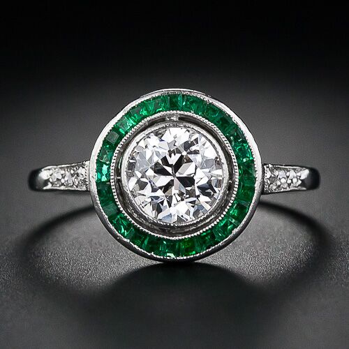 An antique Art Deco diamond engagement ring with calibre emeralds. An antique Art Deco diamond engagement ring with calibre emeralds.