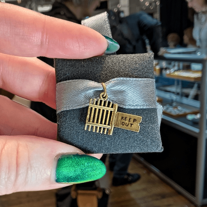 Vintage yellow gold 'keep out' gate charm from Antique Jewelry Expo, seen at NYCJAOS Spring 2026.